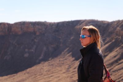 Portrait of man standing on mountain against sky