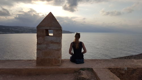 Woman looking at sea against sky