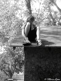 Woman standing on tree trunk