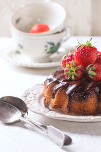 Close-up of fresh cake and strawberries in plate on table