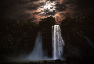 Scenic view of waterfall against sky