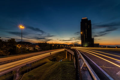 Light trails on road against sky at night