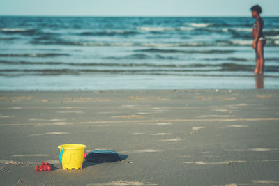 Toy on beach by sea against sky