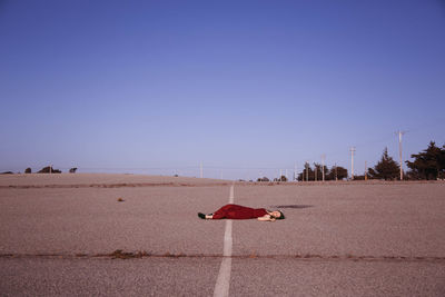 Man on land against clear blue sky