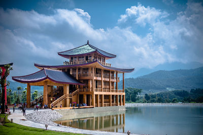 View of building by lake against sky