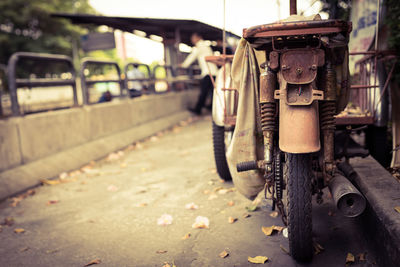 Black and white images of rusty old motorcycles parked on the side of the road.