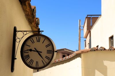 Low angle view of clock against buildings