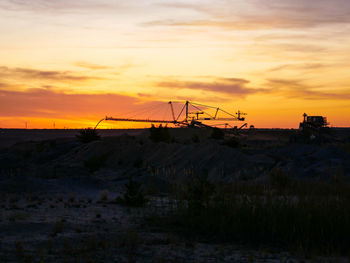 Scenic view of silhouette field against sky during sunset