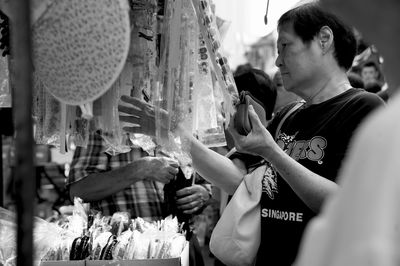 Woman buying hair clip at street market