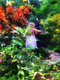 Rear view of woman standing by plants