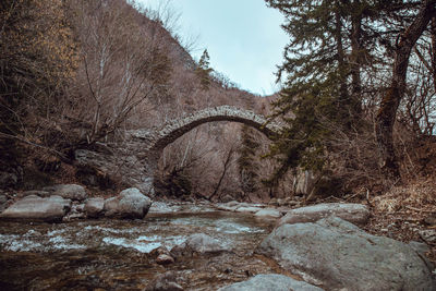 Arch bridge over river against sky