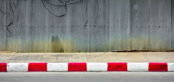 Close-up of white wall with fence