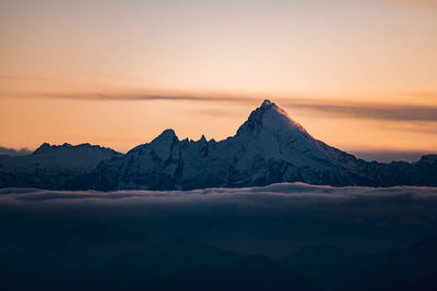 Scenic view of snowcapped mountains against sky during sunset