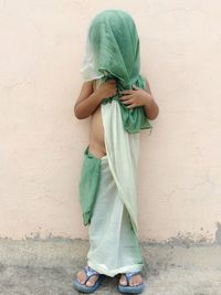 Woman standing by wall