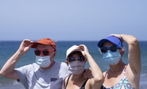 Portrait of friends in sea against sky