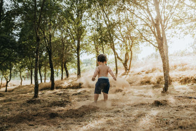 Child playing outdoors with soil