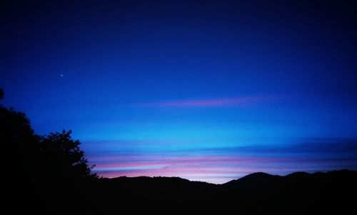 Scenic view of silhouette mountains against sky at sunset