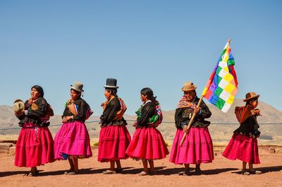 People standing against multi colored umbrellas against clear sky