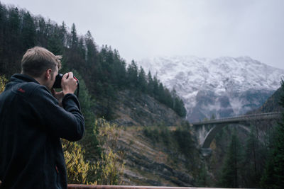 People photographing on mountain during winter