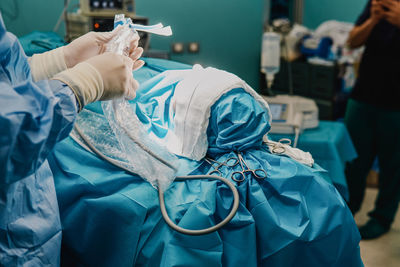 Surgeon team operating patient in surgical room at hospital - focus on scissors