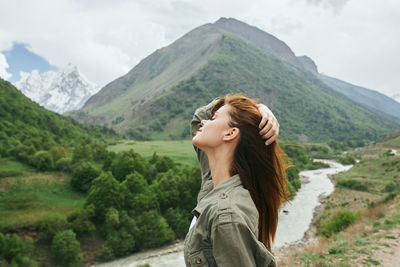 Portrait of young woman looking at mountains