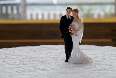 Close-up of wedding couple figurine on tablecloth