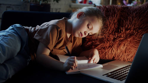 Cute girl writing in book late night