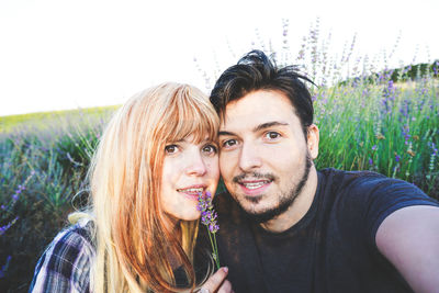 Portrait of smiling young couple on field