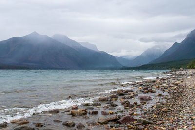 Scenic view of sea and mountains against sky