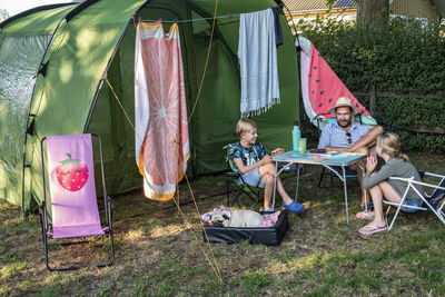 Father with children in front of tent