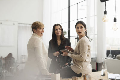 Businesswomen discussing while standing in office