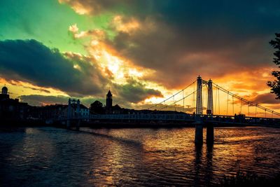 View of bridge over river against cloudy sky