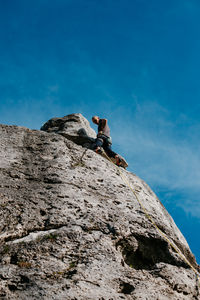 Low angle view of man climbing on rock