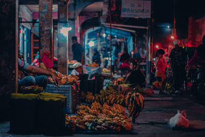 People at market stall at night