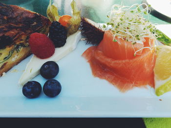 High angle view of fruits and smoked salmon on table