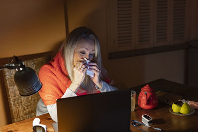 Full length of woman using mobile phone at home