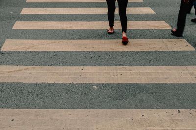 Low section of woman walking on road