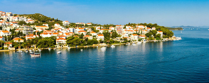 High angle view of houses by sea against clear sky