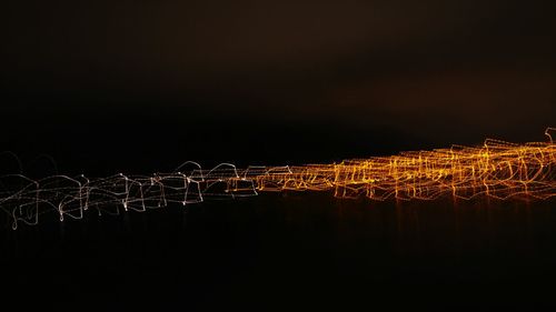 Illuminated light trails against sky at night