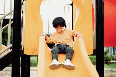 Portrait of boy sitting on play equipment