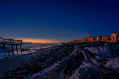 Scenic view of beach against clear sky at sunset