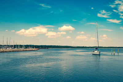 Sailboats in sea against sky