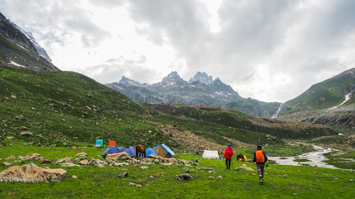 People on mountain against sky