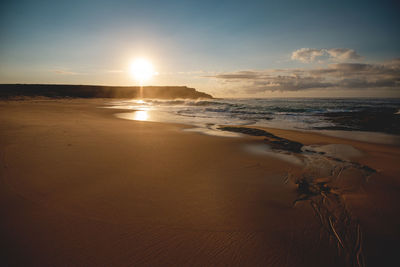 Scenic view of beach against sky during sunset