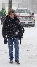 Man standing on snow covered car