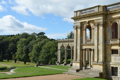 Trees in front of historic building against sky