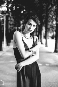 Portrait of beautiful young woman with arms crossed outdoors