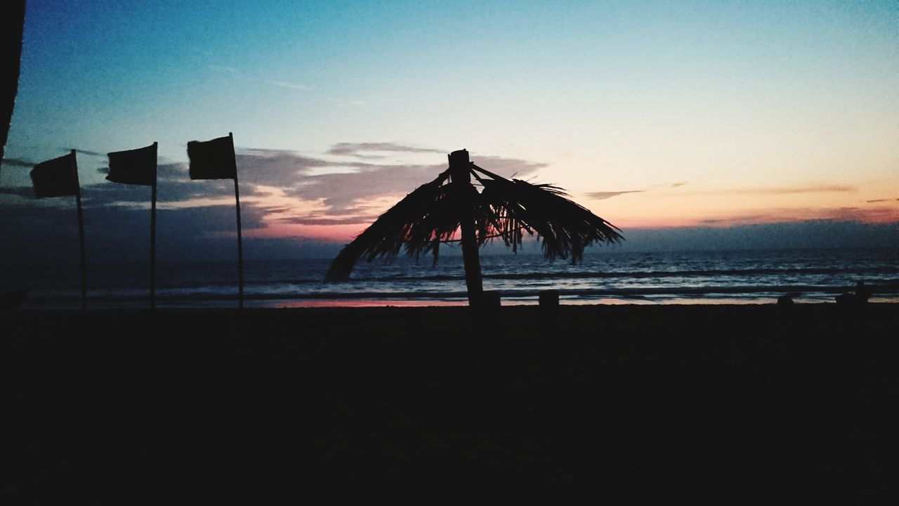 SILHOUETTE LIFEGUARD HUT ON BEACH AGAINST SKY