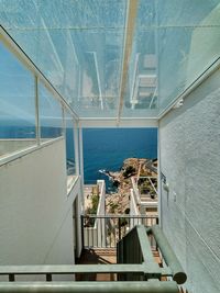 High angle view of sea seen through window in building against sky