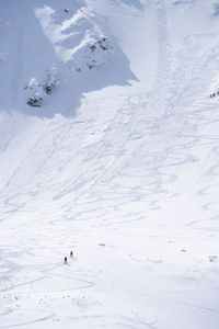 Hikers going through alpine snowy terrain during winter, vertical shot, slovakia, europe